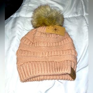 Knit pink beanie with puff ball.